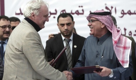 Direktur UNRWA di Gaza Matthias Schmale (kiri) berjabat tangan dengan utusan Qatar Mohammed Al-Emadi di Jalur Gaza, Senin (19/2).