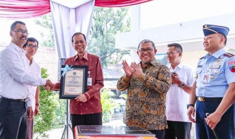 Direktur Utama bank bjb Ahmad Irfan bersalaman dengan Kepala Sekolah SMA Negeri 9 Kota Bandung Agustia Mulyadi (kiri) didampingi Gubernur Jabar Ahmad Heryawan.