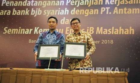 Direktur Utama Bank BJB Syariah Indra Falatehan (kanan) dan Direktur Pemasaran PT Antam TBK Tatang Hendra memperlihatkan Piagam Kerjasama usai penandatanganan kerjasama antara Bank BJB Syariah dan PT Antam di Hotel Prama Grand Preanger Bandung, Kota Bandung, Jumat (14/9).