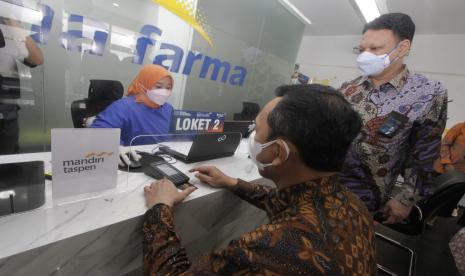 Direktur Utama Bank Mandiri (kiri) Taspen Elmamber P. Sinaga saat ujicoba transaksi kartu debit Bank Mandiri Taspen di mesin edc bersama Plt. Direktur Utama Kimia Farma Diagnostika Agus Chandra (kanan). Ujicoba transaksi kartu debit bank Mandiri Taspen ini dilakukan usai penandatanganan kerja sama potongan harga 10 persen untuk pemeriksaan laboratorium. 