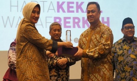 Direktur Utama Bank Mega Syariah Emmy Haryanti (kiri) memberikan piagam kepada Founder ESQ Ary Ginanjar Agustian (kedua dari kanan). Sebelumnya BMS dan perjanjian kerja sama dengan Yayasan Wakaf Bangun Nurani Bangsa (YWBNB) atau sering disebut Yayasan Wakaf ESQ, di Kantor Bank Mega Syariah, Rabu (21/3)