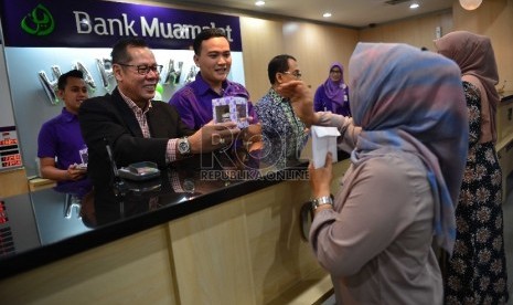 Direktur Utama Bank Muamalat Endy Abdurrahman melayani nasabah di teller Kantor Pusat Bank Muamalat di Jakarta, Jumat (4/9). 