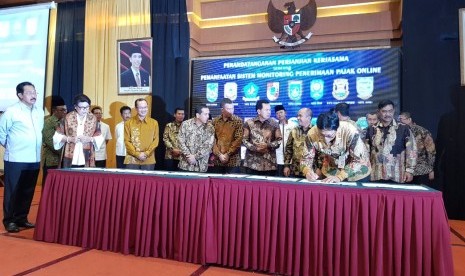 Direktur Utama Bank Sumsel Babel Muhammad Adil menyaksikan pada wali kota dan bupati dari Sumatera Selatan (Sumsel) dan Bangka Belitung (Babel) menandatangani naskah kerjasama pemanfaatan sistem monitoring penerimaan pajak online yang ditandatangani di Batam, Rabu (28/11). 