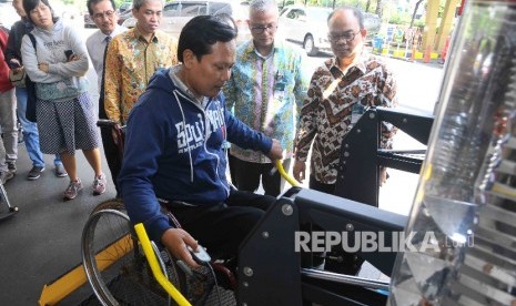 Direktur Utama Bank Syariah Mandiri (BSM), Agus Sudiarto (ketiga kiri) menyaksikan penyandang disabilitas naik ke mobil akses jelang mudik berkah bareng BSM 2016 di Gedung Pusat Bank Syariah Mandiri, Jakarta, Kamis (30/6).  (Republika/Agung Supriyanto)