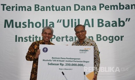 Direktur Utama Bank Syariah Mandiri (BSM) Agus Sudiarto (kiri) secara simbolik menyerahkan bantuan dana pembangunan Mushola Ulil Al Baab kepada Rektor Institut Pertanian Bogor (IPB) Prof. Dr. Ir. Herry Suhardiyanto, M.Scd (kanan) di Kampus IPB, Dramaga, Bo