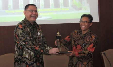 Direktur Utama BNI Syariah, Abdullah Firman Wibowo (kiri), memberikan kenang-kenangan kepada Rektor UGM, Panut Mulyono, pada acara Penandatanganan Nota Kesepahaman (MoU) antara BNI Syariah dan UGM di Gedung Rektorat UGM, Kamis (15/6). 