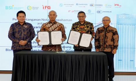 Direktur Utama BSI Hery Gunardi (kiri) bersama Direktur Utama IFG Hexana Trisasongko (kanan) saat menyaksikan penandatanganan oleh Direktur Retail Banking BSI Ngatari (kedua kiri) dan Direktur Keuangan IFG Heru Handayanto (kedua kanan)  terkait pengembangan dan optimalisasi layanan jasa keuangan sesuai dengan prinsip syariah, kolaboratif, dan prudent di Gedung The Tower, Jakarta (18/10).