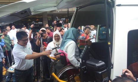 Direktur Utama BSM Toni Subari mendampingi pemudik penyandang disabilitas memasuki mobil akses di kantor pusat BSM, Jumat (23/6). 