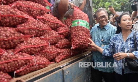 Direktur Utama (Dirut) Bulog, Djarot Kusumayakti (kiri) bersama Menteri BUMN Rini Soemarno melihat bawang merah yang siap dijual dalam operasi pasar di Gudang Bulog Divre Jakarta, Senin (16/5).  (Republika / Wihdan )