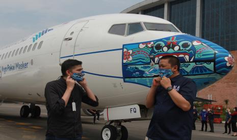 Direktur Utama Garuda Indonesia Irfan Setiaputra (kanan) berbincang dengan pemenang lomba desain livery masker pesawat Jailani (kiri) saat peluncuran pesawat Garuda Indonesia Boing 737-800 NG bercorak khusus yang menampilkan visual masker bertema Indonesia Pride pada bagian moncong pesawat, di Hanggar GMF AeroAsia Bandara Soekarno Hatta, Tangerang, Banten, Senin (12/10/2020). Pemberian gambar masker pada pesawat merupakan dukungan Garuda Indonesia terhadap program edukasi pemerintah melalui kampanye 