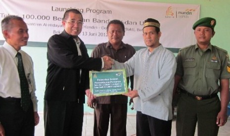 Direktur Utama Laznas BSM Kiagus M Thohir (dua dari kiri) tengah menyerahkan bantuan berupa tiga tambak ikan dengan 200 ribu benih ikan dan udang kepada Pimpinan Pesantren Al Hidayah Babelan, Bekasi, Jawa Barat Ustadz Komarudin (dua dari kanan)