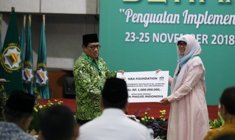 Direktur Utama NRA Group, Irmawati Mochtar (kanan) menyerahkan secaa secara simbolis bantuan renovasi 100 masjid di Palu, Sigi dan Donggala, kepada Sekjen DMI, Imam Addaruquthni.