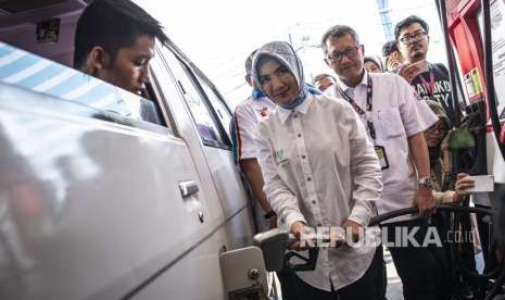 Direktur Utama Pertamina Nicke Widyawati (tengah) mengisi BBM ke kendaraan pelanggan di SPBU Coco Kuningan, Jakarta, Senin (3/9). 