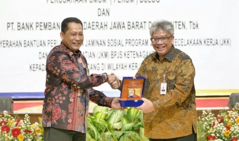 Direktur Utama Perum Bulog Budi Waseso (kiri) dan Dirut Bank BJB Yuddy Renaldi berbagi cinderamata dalam ajang penandatanganan Memorandum of Understanding (MoU) di Kantor Pusat Perum Bulog, Jakarta, Rabu (31/7).     