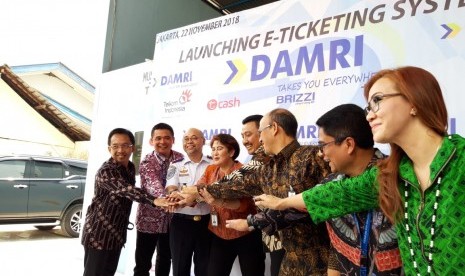 Direktur Utama Perum Damri Setia N Milatia Moemin (tengah) bersama Kepala BPTJ Bambang Prihantono (baju putih), Direktur Enterprise and Business Service PT Telkom Dian Rachmawan (batik merah bata) menunjukkan uang elektronik di Pool Damri Kemayoran, Jakarta pada Kamis (22/11). 