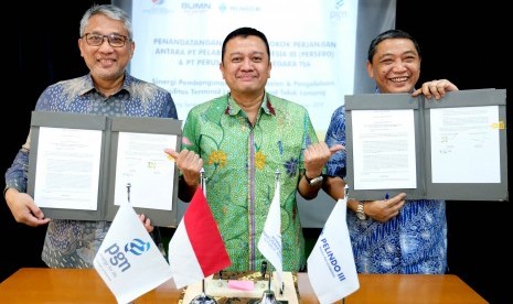 Direktur Utama PGN Gigih Prakoso (kiri) dan Direktur Utama Pelindo III Doso Agung (kanan) disaksikan Deputi Bidang Usaha Energi, Logistik, Kawasan dan Pariwisata Kementerian BUMN, Edwin Hidayat Abdullah (tengah) menunjukkan nota kerjasama seusai penandatanganan di Jakarta, Rabu (26/6/2019).