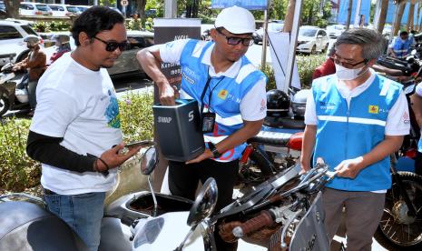 Direktur Utama PLN Darmawan Prasodjo (tengah) didampingi Direktur Niaga dan Manajemen Pelanggan PLN Bob Saril (kanan) mengamati sepeda motor konvensional yang telah dikonversi menjadi kendaraan listrik saat kegiatan PLN E-Mobility Day: Driving The Future di Denpasar, Bali, Ahad (24/7/2022). Kegiatan itu diselenggarakan PLN dalam upaya mengkampanyekan penggunaan kendaraan listrik guna mendukung transisi menuju energi bersih. 