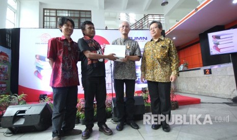 Direktur Utama PT Pos Indonesia (Persero) Gilarsi Wahju Setijono (kedua kanan) bersama pihak terkait secara simbolis memegang buku untuk dikirim ke berbagai daerah pada peresmian Donasi Buku untuk Masyarakat, di Kantor POS Indonesia, Jalan Asia Afrika, Kota Bandung, Jumat (15/12).