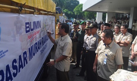 Direktur Utama PT Pusri Mulyono Prawiro menandatangani spanduk sebagai tanda melepas truk barang kebutuhan pokok yang akan dijual pada pasar murah ramadhan di halaman kantor PT Pusri, Selasa (13/6). 