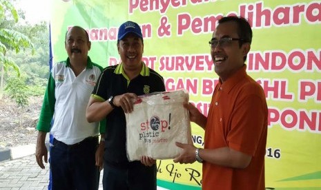 Direktur Utama PT Surveyor Indonesia M Arif Zainuddin (tengah) memberikan tas belanja ramah lingkungan di sela acara penanaman pohon tanaman keras oleh PT Surveyor Indonesia di Semarang, Jumat (15/4).