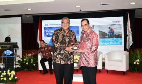 Direktur Utama  PT Surveyor Indonesia (Persero) Dian M. Noer (kiri) menyerahkan kenang-kenangan kepada Menteri Perhubungan, Budi Karya Sumadi, pada acara Surveyor Indonesia Outlook 2019  di Jakarta, Jumat (19/10).