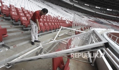 Direktur Utama Pusat Pengelola Kompleks Gelora Bung Karno (PPK GBK) Winarto memeriksa kondisi pagar pembatas lapangan yang rusak di Stadion Utama GBK, Senayan, Jakarta, Ahad (18/2).