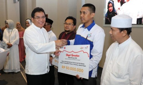 Direktur Utama Telkom Alex J. Sinaga (paling kiri) menyerahkan simbolis bantuan sarana dan prasarana kepada salah satu pesantren dalam acara Blissful Ramadhan TelkomGroup 2019 di Masjid Al-Istiqomah Telkom Landmark Tower, Jakarta, Selasa (21/5). 