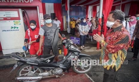 Dirjen Bina Pemerintahan Desa Kemendagri Yusharto Huntoyungo (kanan) menyapa pelanggan di Pertashop Desa Planjan, Kesugihan, Cilacap, Rabu (15/12/2021). Pertashop yang dikelola oleh BUMDes Nogrohu Sejahtera Desa Planjan ini merupakan program percontohan nasional untuk mempercepat persebaran Pertashop di desa-desa yang merupakan kerjasama antara Kemendagri dengan PT Pertamina dalam meningkatkan nilai ekonomi masyarakat pedesaan. 