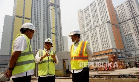 Dirjen Penyediaan Perumahan Kemen PUPR Syarif Burhanuddin (tengah) berbincang dengan Pejabat Pembuat Komitmen Rumah Susun Bertingkat Tinggi Kemayoran Ditto Ferakhim (kiri) dan Kepala Satuan Kerja Pengembangan Perumahan Erizal usai meninjau proyek pembangunan rusun wisma atlet Kemayoran, Jakarta, Rabu (19/7).