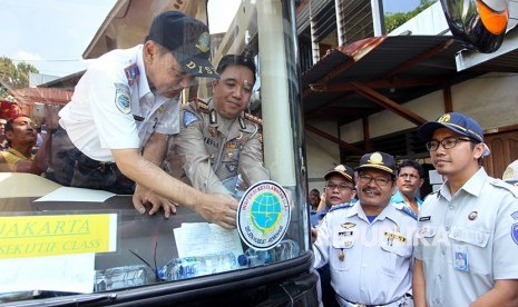 Dirlantas Polda Bengkulu Kombes Pol Jefri Yanus (kedua kiri) bersama Kepala Dinas Perhubungan Provinsi Bengkulu Budi Djatmiko (kiri) memasang stiker Inspeksi Keselamatan LLAJ Angkutan Mudik 2018 di salah satu bus yang sudah lulus uji kelayakan, di Po. San Bengkulu, Rabu (6/6).