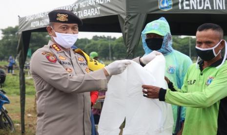 Dirsamapta Polda Metro Jaya, Kombes Pol Mohamad Ngajib (kiri) menyerahkan bantuan APD untuk tenaga pemakaman jenazah.