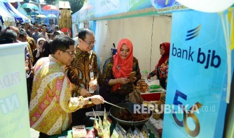 Dirut Bank BJB Ahmad Irfan dan Kepala OJK Regional Jabar Sarwono (kiri) meninjau stand Usaha Mikro Kecil dan Menengah (UMKM) pada Bazaar UMKM dan Travel Fair 2017 di halaman kantor pusat Bank BJB, Kota Bandung, Kamis (18/5). 