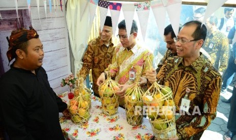 Dirut Bank BJB Ahmad Irfan (kanan) dan Kepala OJK Regional Jabar Sarwono (ketiga kanan) meninjau stand Usaha Mikro Kecil dan Menengah (UMKM) pada Bazaar UMKM dan Travel Fair 2017 di halaman kantor pusat Bank BJB, Kota Bandung, Kamis (18/5).