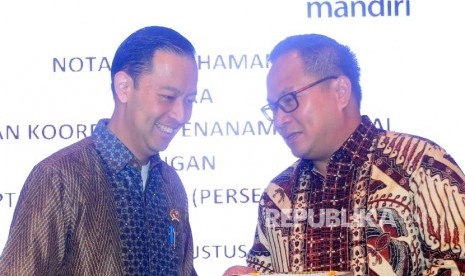 Dirut Bank Mandiri, Kartika Wiroatmojo (kanan) berbincang dengan Kepala Badan Koordinasi Penanaman Modal (BKPM) Thomas Lembong (kiri) usai penandatanganan MoU kerjasama untuk investasi di Gedung BKPM, Jakarta, Selasa (9/8). 