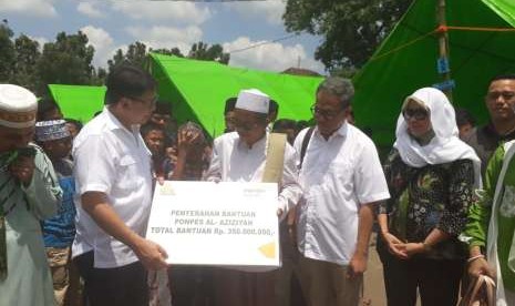 Dirut Bank Syariah Mandiri (BSM) Toni Eko Boy Subari menyerahkan bantuan kepada Ponpes Al Aziziyah di Dusun Kapek, Desa Gunungsari, Kecamatan Gunungsari, Kabupaten Lombok Barat, NTB, yang rusak akibat gempa, Senin (10/9).   