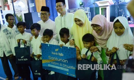 Dirut BJB Ahmad Irfan di dampingi Gubernur Jawa Barat Ahmad Heryawan berfoto bersama dengan anak Yatim dan Dhuafa usai memberikan santunan secara simbolis kepada 2500 Yatim dan Dhuafa, saat acara berbuka puasa bersama dan peresmian Masjid Baitul Mughni, di halaman kantor pusat Bank BJB, Kota Bandung, Rabu (23/5). 