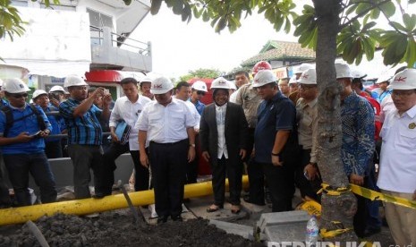 Dirut PGN Hendi Prio Santoso (kanan) berjalan bersama Menteri ESDM Sudirman Said serta Walikota Surabaya Tri Rismaharini saat meninjau pemasangan pipa jaringan gas (jargas) ke rumah tangga di Rungkut, Surabaya. (Republika/Rachmat Santosa Basarah)