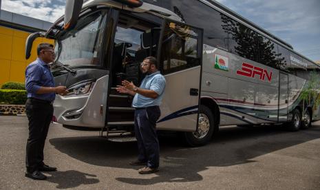 Dirut PT SAN Putera Sejahtera (PO SAN) Kurnia Lesani Adnan (kanan) berbincang dengan Departemen Head Truck Sales Operation PT United Tractors Tbk, Suhardi (kiri) di depan bus Scania K410IB-6x2 usai serah terima bus baru tersebut di Semarang, Jawa Tengah, Rabu (23/12/2020).