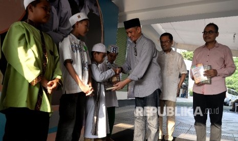 Dirut Republika Media Mandiri Agoosh Yoosran (ketiga kanan) bersama Managing Director Sinarmas Saleh Husin (kedua Kanan) dan Pemred Republika Irfan Junaidi (kanan) dan memberikan wakaf Al-Quran dan Juz'Amma secara simbolis disela acara buka bersama dan santunan anak yatim di Kantor Republika, Jakarta, Sabtu (17/6).