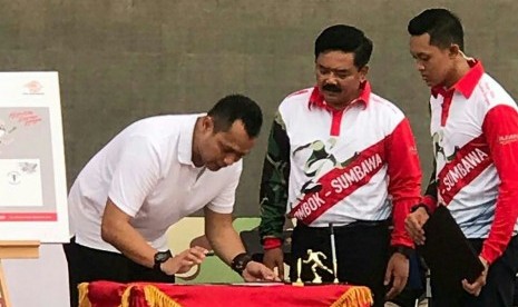 Disaksikan Panglima TNI  Marsekal Hadi Tjahjanto SIP (tengah), Direktur Hubungan Strategis dan Kelembagaan PT Pos Indonesia Noer Fajrieansyah (kiri)  menandatangani naskah peluncuran Sampul Peringatan dan Prangko Prisma seri TNI Mandalika International Marathon 2018 PT Pos Indonesia mewarnai puncak acara peringatan HUT TNI ke-73 di Lombok, Nusa Tenggara Barat, Ahad (4/11).