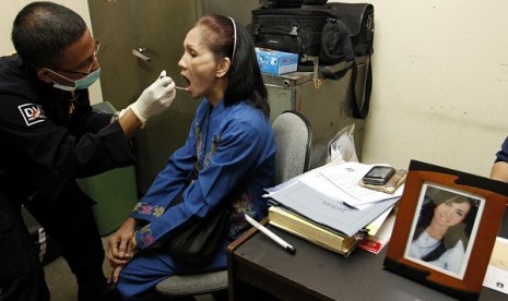 Disaster Victim Identification (DVI) personnel from Indonesian police (left) takes DNA sample from a relative of one of Sukhoi victims at Halim Perdanakusuma Airport, Jakarta, Thursday.  