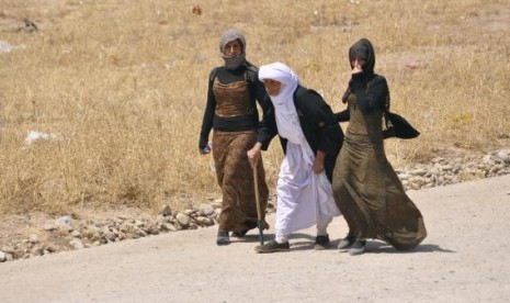 Displaced families from the minority Yazidi sect, fleeing the violence, walk on the outskirts of Sinjar, west of Mosul, August 5, 2014.