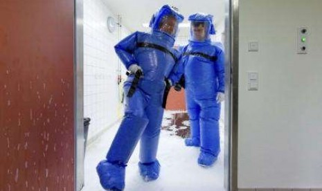 Doctor for tropical medicine Florian Steiner (right) and ward physician Thomas Klotzkowski step out of a disinfection chamber at the Charite hospital in Berlin August 11, 2014.