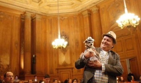 Dog owner Dean Clark presents Frida, a female Chihuahua, as the San Francisco Board of Supervisors issues a special commendation naming Frida 'Mayor of San Francisco for a Day' in San Francisco, California November 18, 2014.