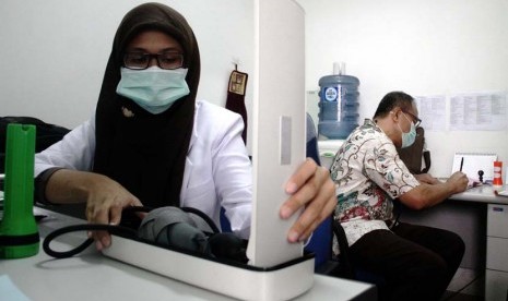 Dokter memeriksa pasien di Puskesmas Johar Baru, Jakarta Pusat, Kamis (12/6). Untuk meningkatkan pelayanan kesehatan bagi warganya, Pemrov DKI Jakarta mengubah 18 puskesmas dari 44 puskesmas tingkat kecama