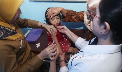 Dokter menyuntikkan vaksin kepada balita yang terpapar vaksin palsu saat melakukan vaksinasi ulang, di rumah sakit Rawalumbu, Bekasi, Jawa Barat.