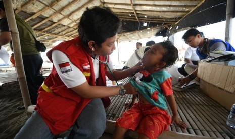  Dokter Septian Dwi Nurcahyo (31) dari RSPP sedang memeriksa kesehatan salah satu warga yang membantu penanganan pembersihan tumpahan minyak mentah dan diberikan sebuah pita berwarna sebagai tanda bahwa kesehatanya baik, pada selasa (30/7) di Posko Desa Sedari.