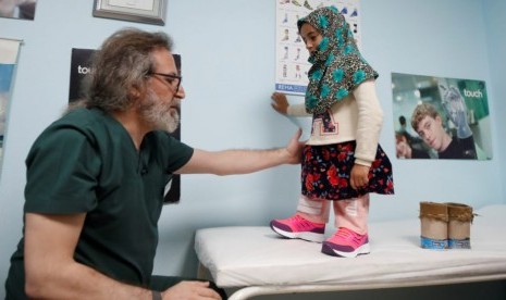 Dokter spesialis prostetik dari Turki, Mehmet Zeki Culcu memasang kaki palsu untuk gadis Suriah Maya Merhi di Istanbul, Turki..