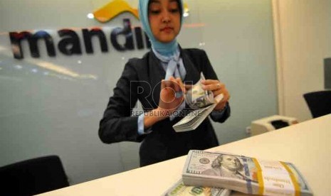 Dolar AS Melemah. Petugas menghitung mata uang Dolar AS di Bank Mandiri, Jakarta, Selasa (19/8). (Republika/ Wihdan).