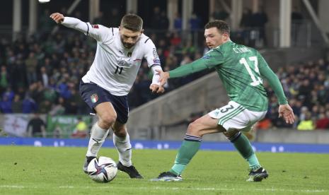 Domenico Berardi dari Italia, kiri, mengambil bola melewati Corry Evans dari Irlandia Utara selama pertandingan sepak bola kualifikasi grup C Piala Dunia 2022 antara Irlandia Utara dan Italia di stadion Windsor Park di Belfast, Irlandia Utara, Senin, 15 November 2021.